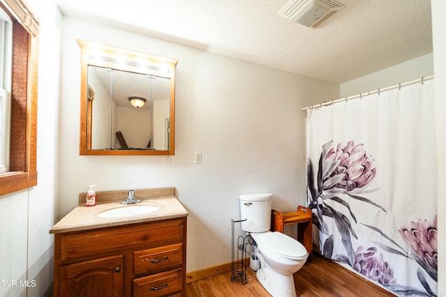 bathroom with vanity, hardwood / wood-style floors, toilet, and a textured ceiling