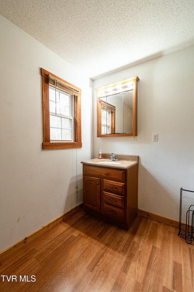 bathroom featuring vanity, hardwood / wood-style flooring, and a textured ceiling