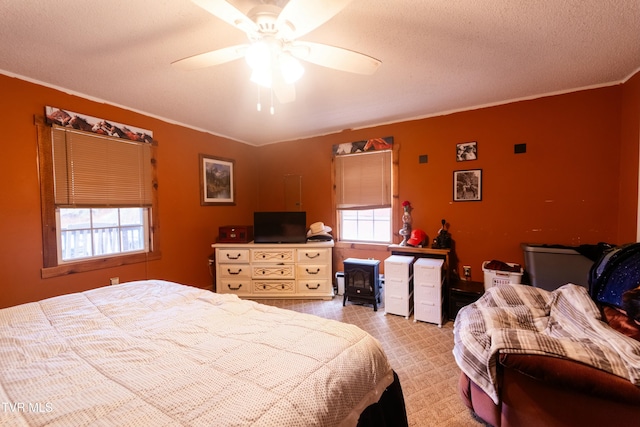 bedroom featuring multiple windows, ceiling fan, crown molding, and a textured ceiling