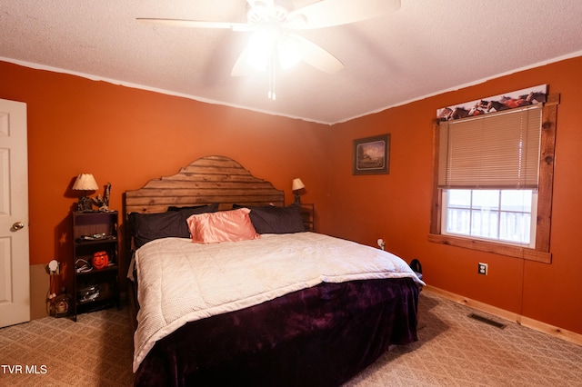 bedroom with crown molding, ceiling fan, light carpet, and a textured ceiling