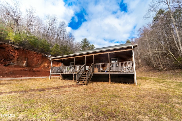 rear view of house with a lawn and a deck