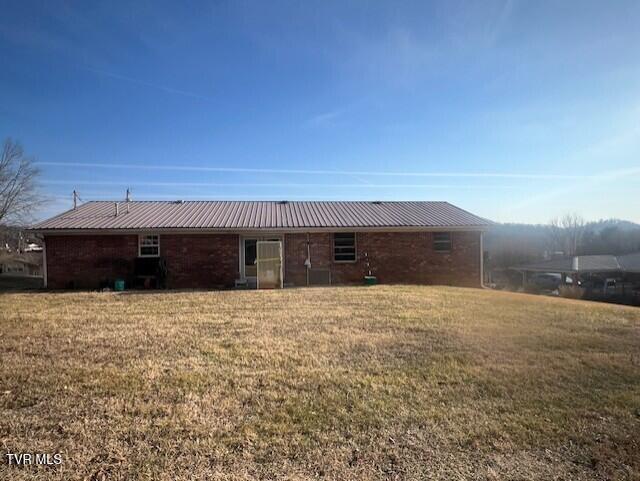 rear view of property featuring a yard