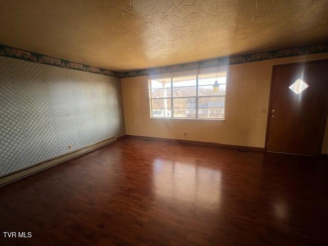 empty room featuring dark hardwood / wood-style flooring and a textured ceiling