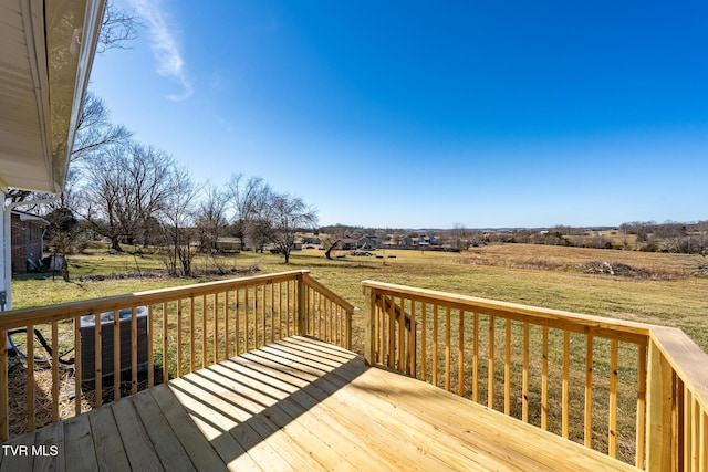 deck with a rural view and a lawn