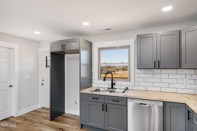 kitchen featuring gray cabinets, wood counters, dishwasher, sink, and light hardwood / wood-style floors