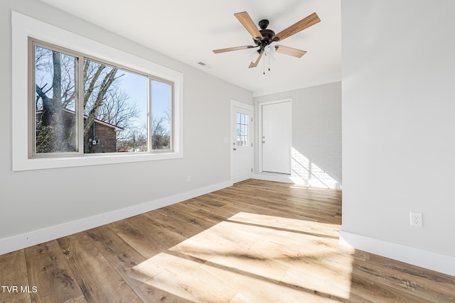 interior space featuring ceiling fan, wood-type flooring, and a healthy amount of sunlight