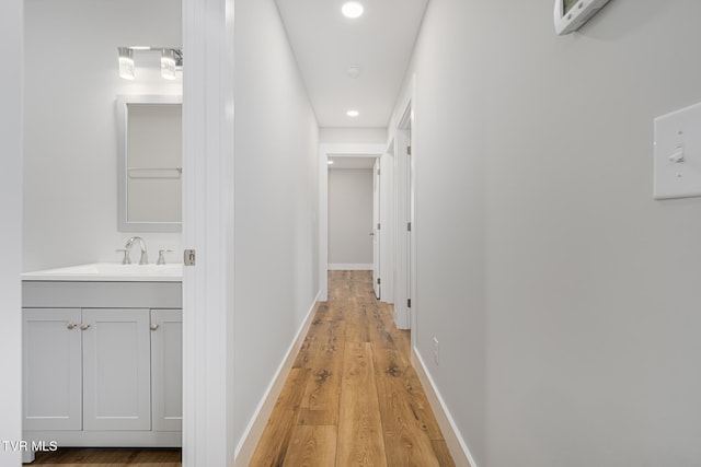 hall featuring sink and light hardwood / wood-style floors