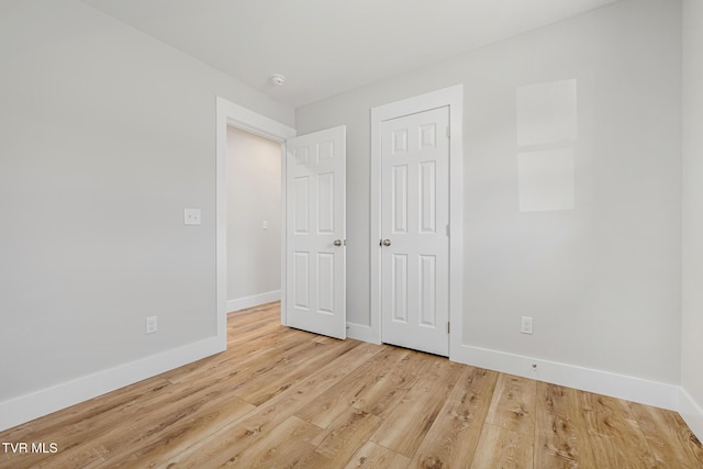 unfurnished bedroom featuring light hardwood / wood-style floors and a closet