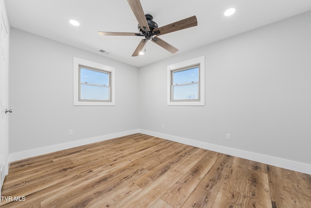 unfurnished room featuring a healthy amount of sunlight, ceiling fan, and light hardwood / wood-style flooring