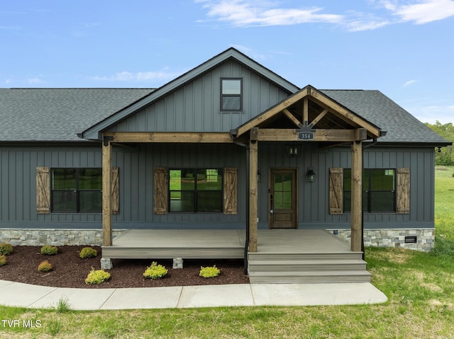 view of front of home with board and batten siding, covered porch, and a shingled roof