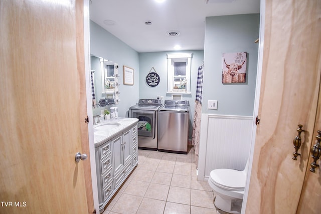 bathroom with tile patterned flooring, vanity, washer and clothes dryer, and toilet