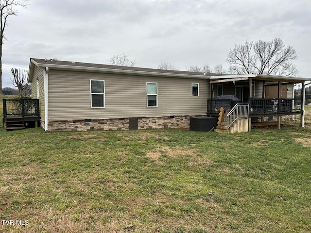 back of house with a wooden deck and a yard