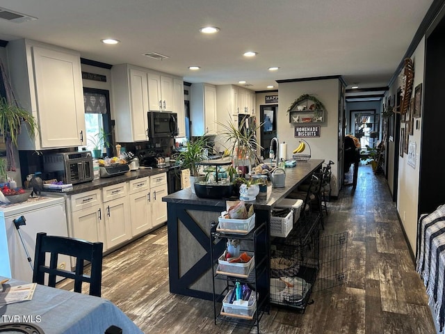 kitchen featuring white cabinetry, backsplash, black appliances, and dark hardwood / wood-style floors