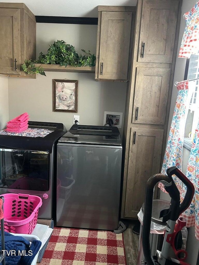 clothes washing area featuring cabinets, separate washer and dryer, and hardwood / wood-style floors