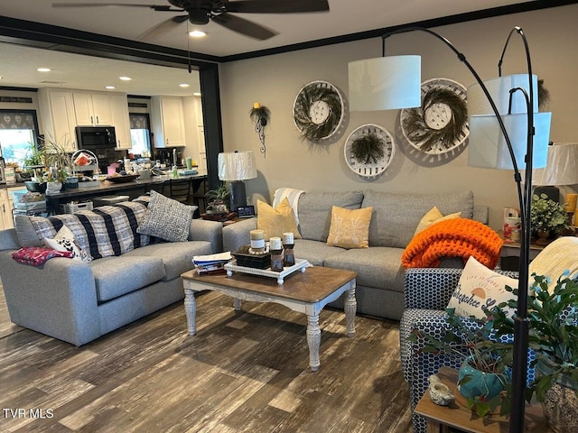 living room with ceiling fan, ornamental molding, and dark hardwood / wood-style flooring