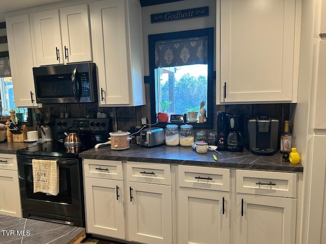 kitchen with white cabinetry, backsplash, and electric range