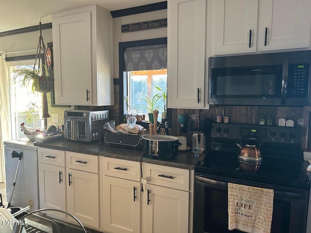 kitchen with white cabinetry, electric range, and tasteful backsplash