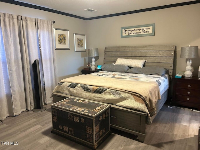 bedroom featuring hardwood / wood-style flooring and ornamental molding