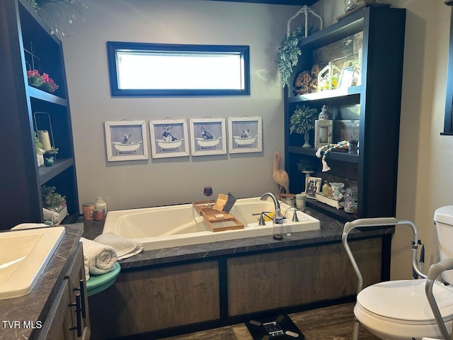 bathroom featuring vanity, hardwood / wood-style floors, a bathing tub, and toilet