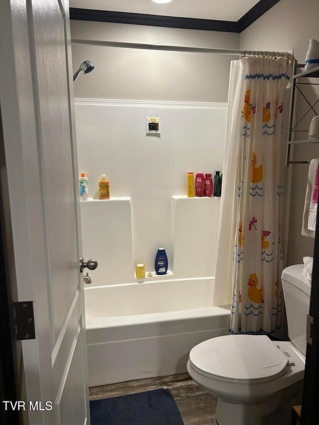 bathroom with wood-type flooring, shower / bath combination with curtain, and toilet