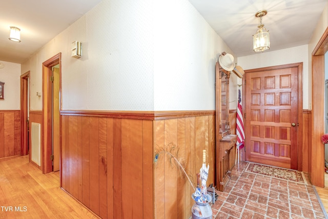 foyer entrance featuring wooden walls