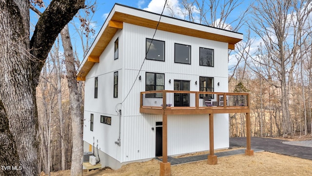 rear view of property featuring a wooden deck and central air condition unit