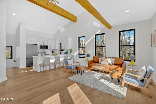 living room featuring high vaulted ceiling, light wood-type flooring, and beam ceiling