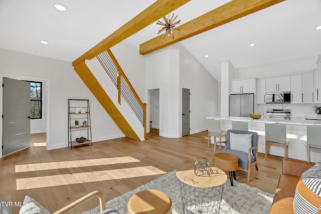 living room with high vaulted ceiling, beam ceiling, and light hardwood / wood-style flooring