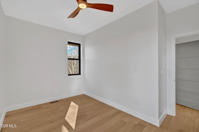 empty room featuring vaulted ceiling, light hardwood / wood-style floors, and ceiling fan