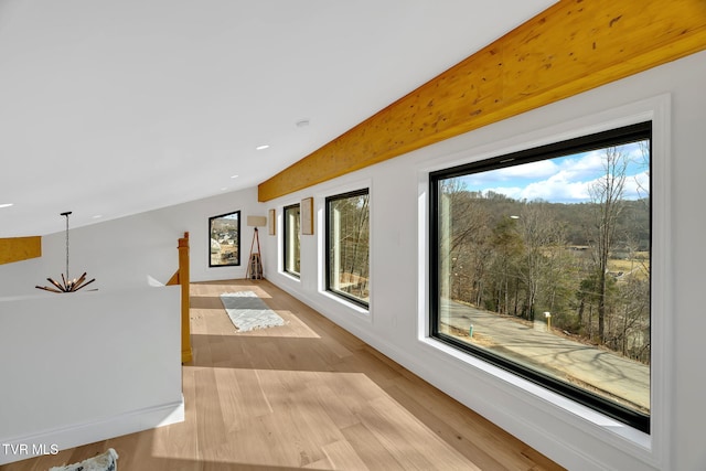 corridor with a notable chandelier and light hardwood / wood-style flooring