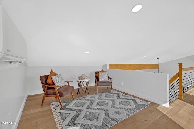 living area featuring vaulted ceiling and light hardwood / wood-style flooring