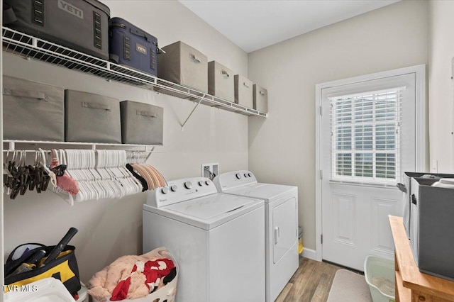 clothes washing area with separate washer and dryer and light hardwood / wood-style flooring