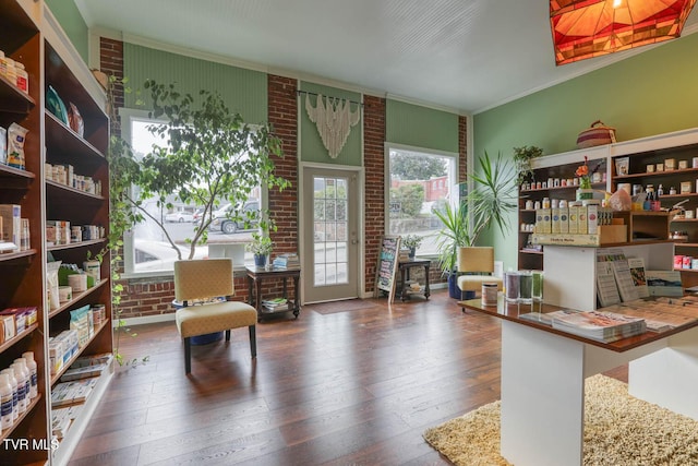 sitting room with crown molding, brick wall, and dark hardwood / wood-style floors