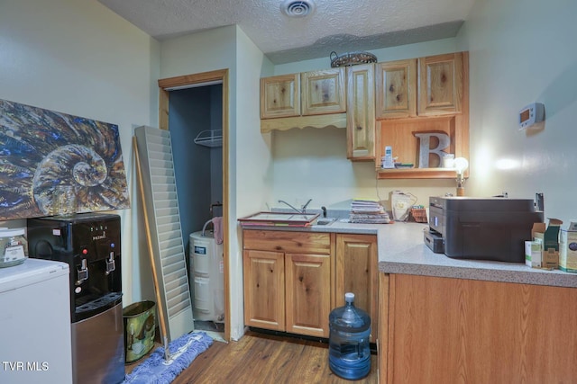 kitchen featuring dark hardwood / wood-style floors, washer / dryer, sink, and a textured ceiling