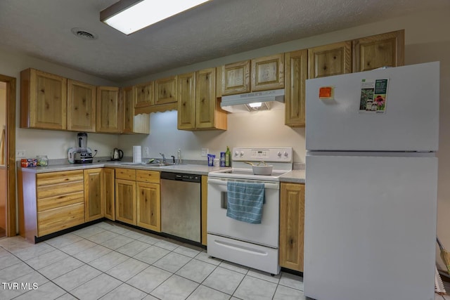 kitchen with sink, light tile patterned floors, a textured ceiling, and white appliances