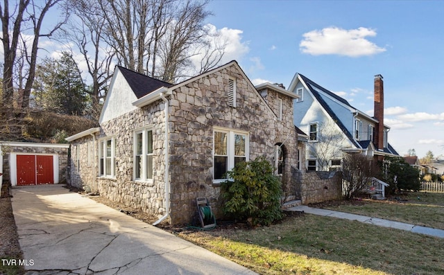 view of front of home with stone siding and a lawn