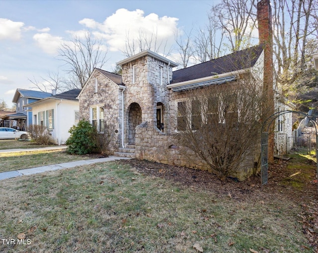 view of front of home featuring stone siding and a front lawn