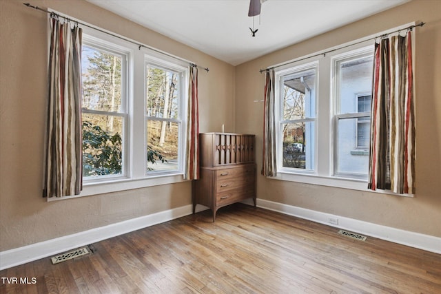 spare room with light wood-style floors, baseboards, and visible vents