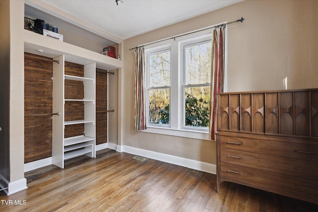 bedroom featuring wood finished floors, visible vents, and baseboards