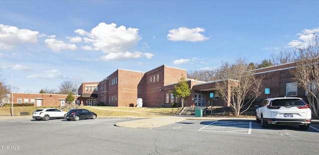 view of building exterior featuring uncovered parking and a residential view