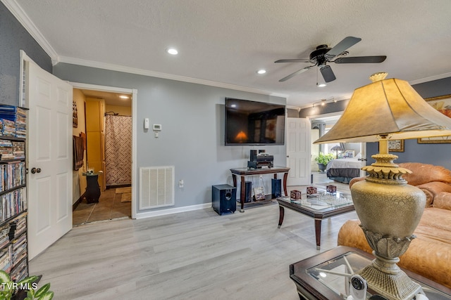 living room with ceiling fan, ornamental molding, a textured ceiling, and light hardwood / wood-style flooring