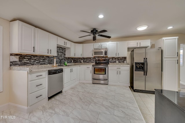 kitchen with white cabinetry, appliances with stainless steel finishes, sink, and lofted ceiling