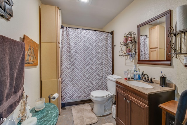 bathroom featuring tile patterned flooring, vanity, walk in shower, and toilet