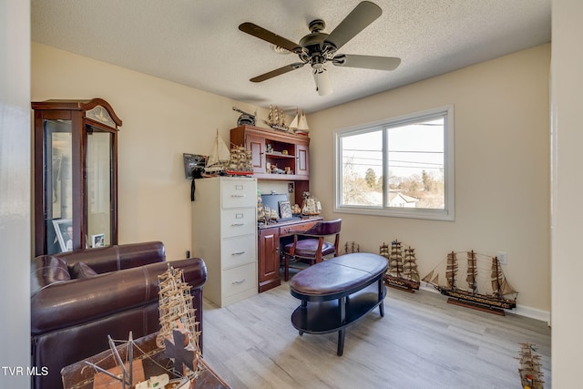 office featuring ceiling fan, light hardwood / wood-style flooring, and a textured ceiling