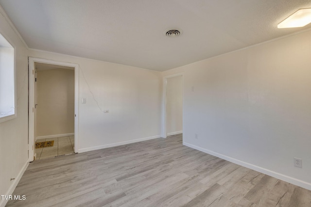 spare room featuring a textured ceiling and light wood-type flooring