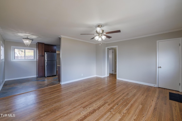 unfurnished living room featuring wood-type flooring, ceiling fan with notable chandelier, and crown molding