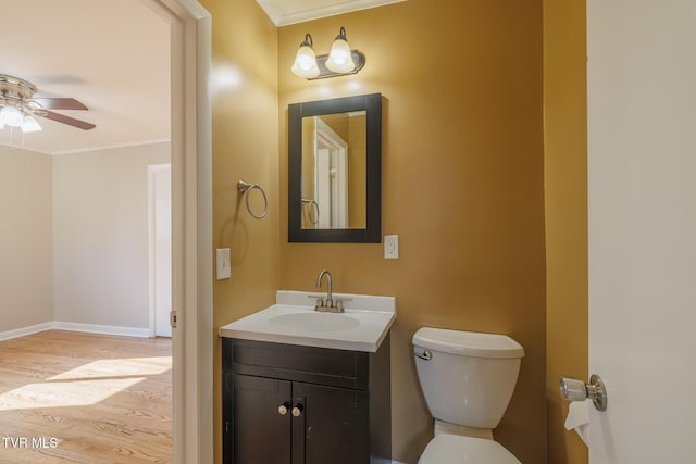 bathroom with ceiling fan, hardwood / wood-style floors, vanity, ornamental molding, and toilet