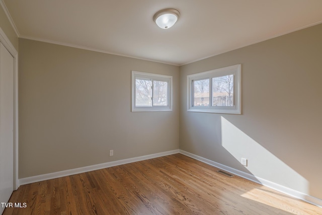 spare room with crown molding and light hardwood / wood-style flooring