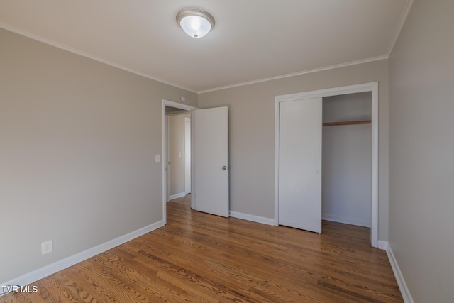 unfurnished bedroom with ornamental molding, hardwood / wood-style floors, and a closet