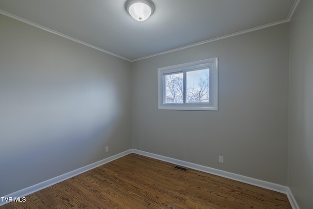 empty room featuring ornamental molding and dark hardwood / wood-style flooring